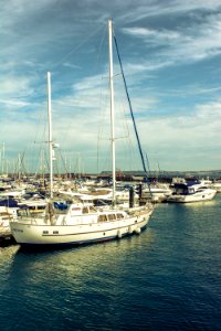 docked boat on water under blue and white cloudy sky photo