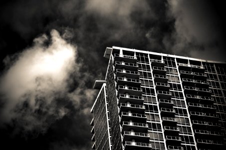 grayscale photography of building under cloudy sky photo