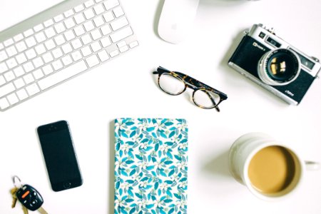 black frame eyeglasses beside black and gray SLR camera