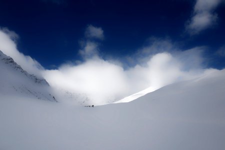 people walking on snow under cloudy sky photo