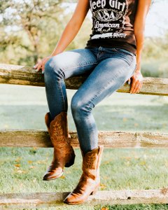 woman sitting on brown wooden fence photo