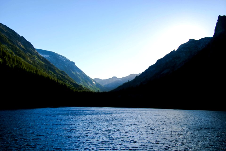 landmark photography of body of water surrounded by green mountains during daytime photo