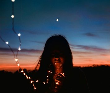 woman holding gold string lights photo