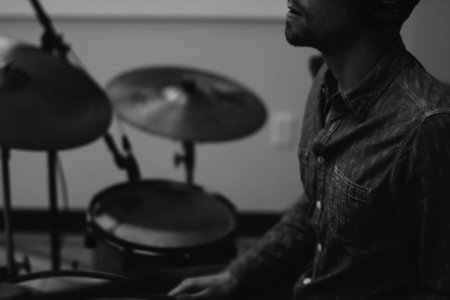 grayscale photo of man playing drum photo