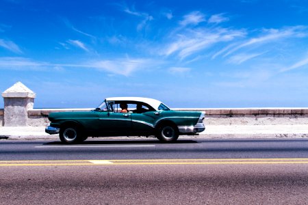 green coupe on gray asphalt road photo