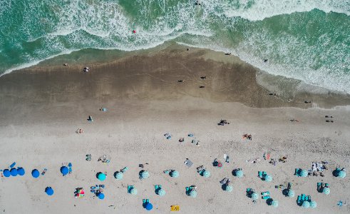 bird's eye view of people on shoreline near body of water photo