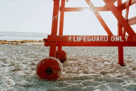 red lifeguard post near shoreline during daytime photo