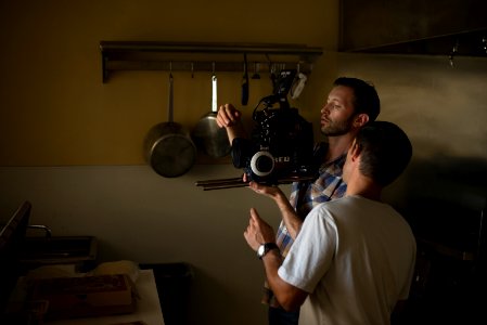 two men fixing camera inside kitchen