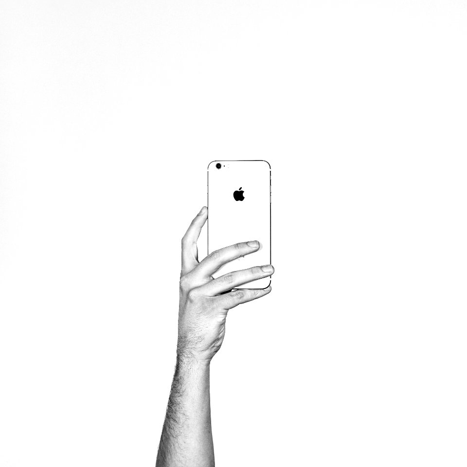 A person holding up an Apple phone.