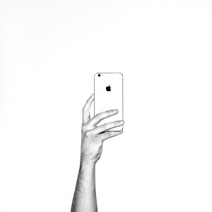 A person holding up an Apple phone.