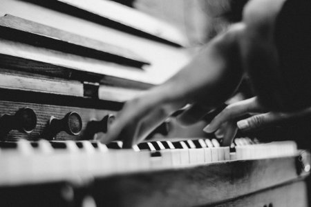 gray scale photo of person playing piano photo
