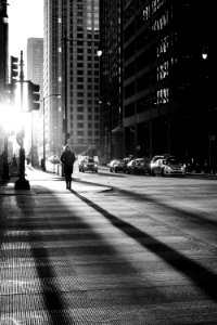 grayscale photo of woman walking on road photo
