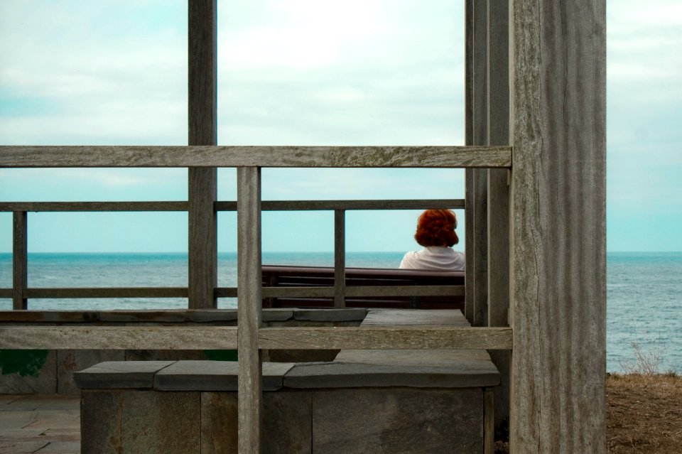 woman in white long sleeve shirt sitting on gray concrete stairs