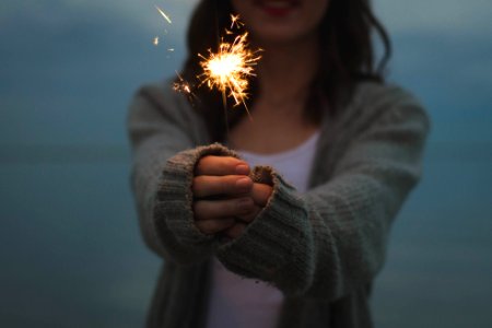 focus photo of a woman holding sparklers photo
