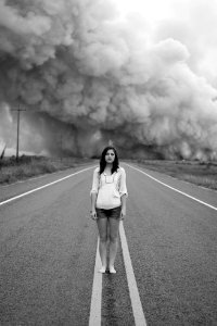 grayscale photo of woman standing in the middle of the road photo