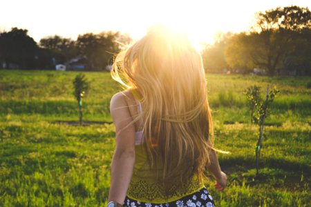 woman walking on lawn with trees photo