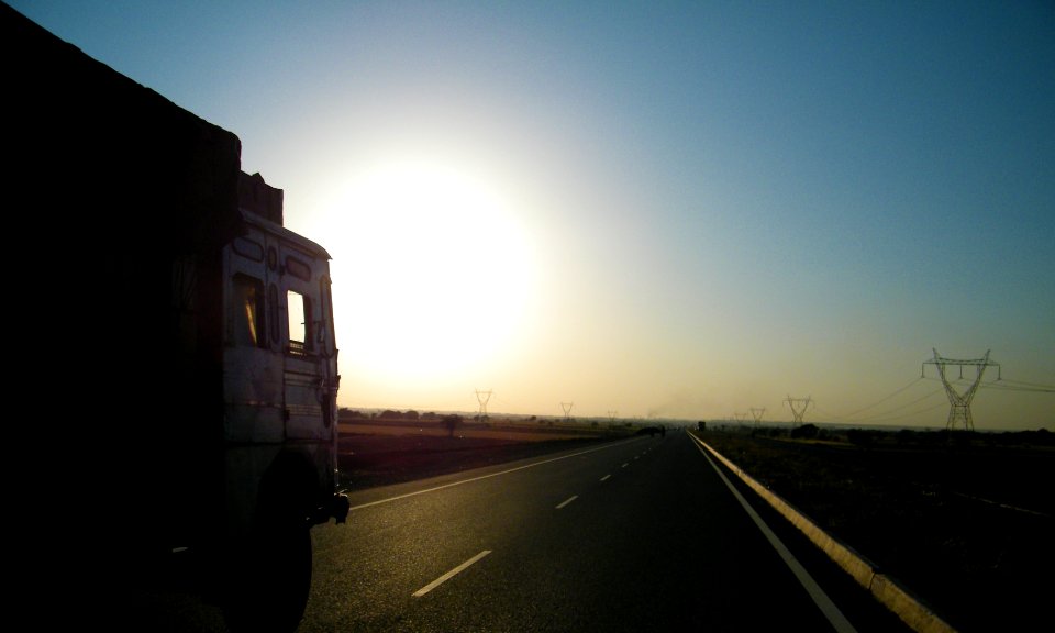 gray truck on asphalt road during sunset