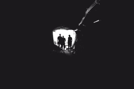 three person standing in tunnel photo