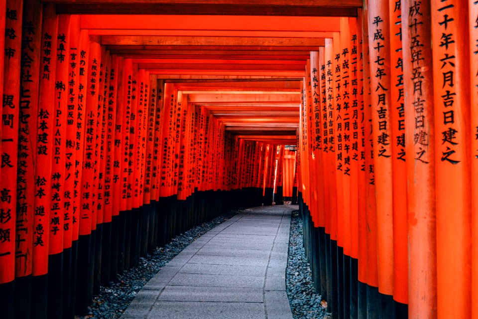 gray pathway between red and black wooden pillar