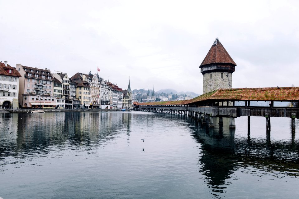 body of water near concrete buildings under white and gray sky at daytime photo