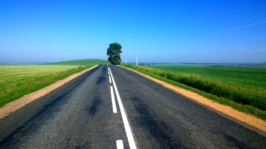 road between green grass covered plains photo