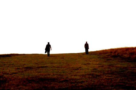 silhouette of two person on hill photo