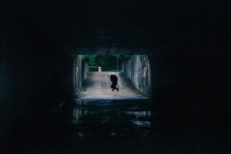 silhouette of person inside tunnel