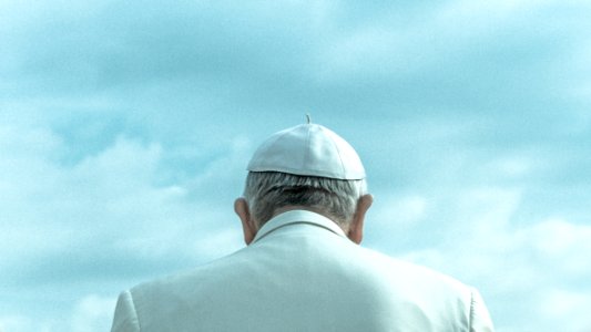 person wearing white cap looking down under cloudy sky during daytime photo