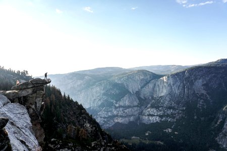 person standing on edge of mountain photo
