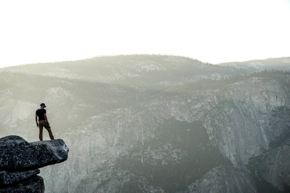 person standing near rock cliff