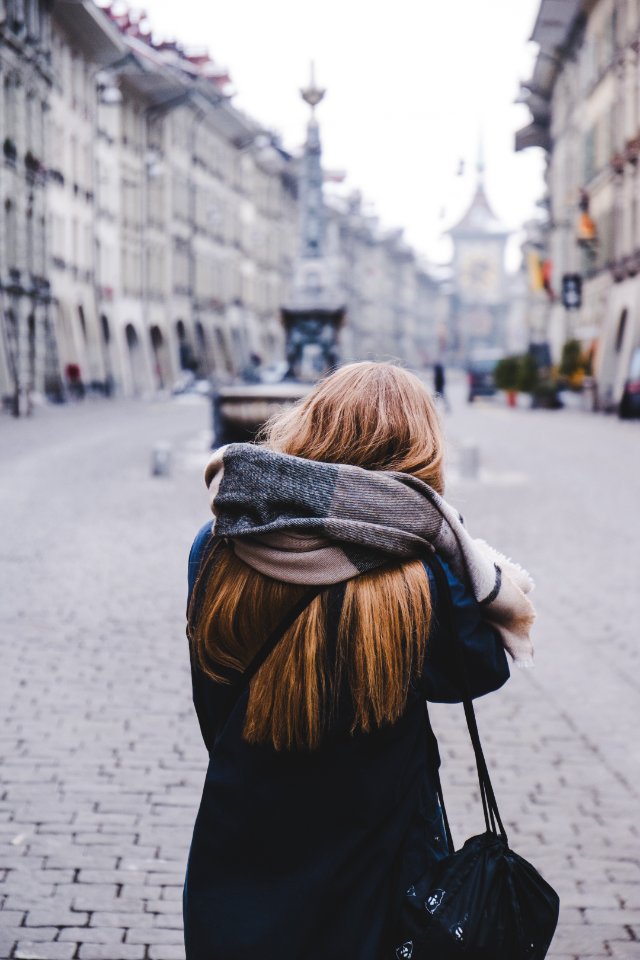 woman standing on sidewalk during daytime photo