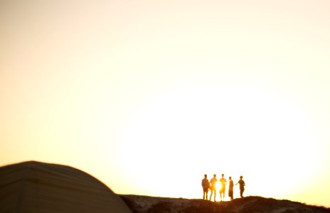 five men standing on a cliff