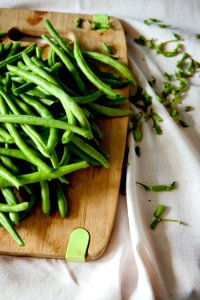 green peas on top of brown wooden chopping board