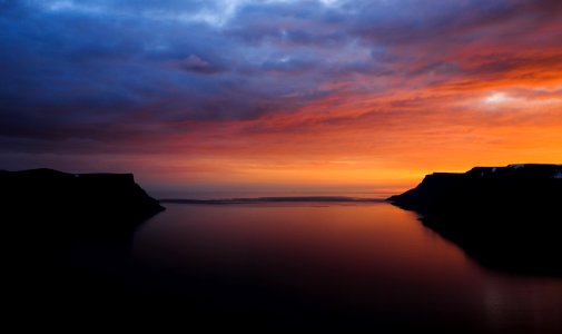 body of water under orange sunset
