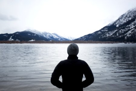man in black top standing in front of lake photo