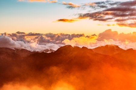 landscape photography of mountains with cloudy skies during golden hour photo