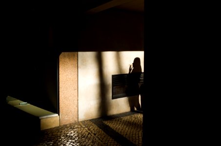 shadow of a woman smoking on brown wall photo