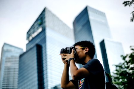 man wearing black t-shirt holding DSLR camera photo