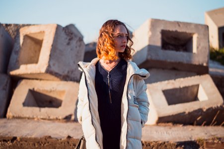 woman in white full-zip bubble jacket standing and looking right side photo