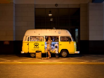 woman and child standing in front of yellow bus in car park photo