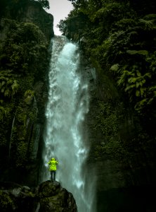 man standing on rock infront of waterfalls photo