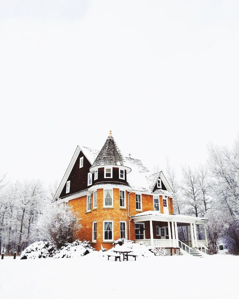 orange and gray concrete house surround by snow photo