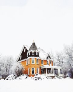 orange and gray concrete house surround by snow photo