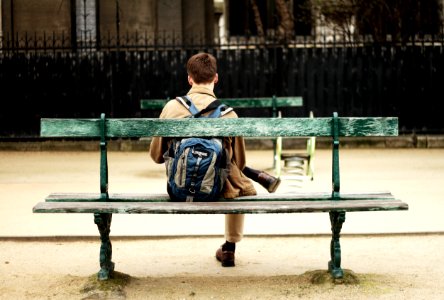 man in brown shirt sitting on bench