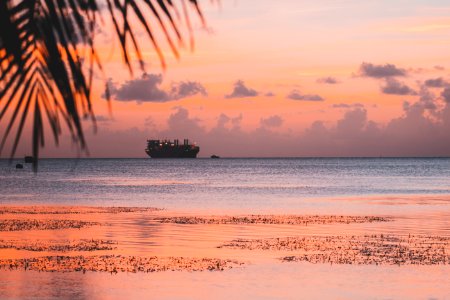 silhouette of ship on body of water during golden hour photo