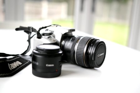 black Canon DSLR camera on white surface photo