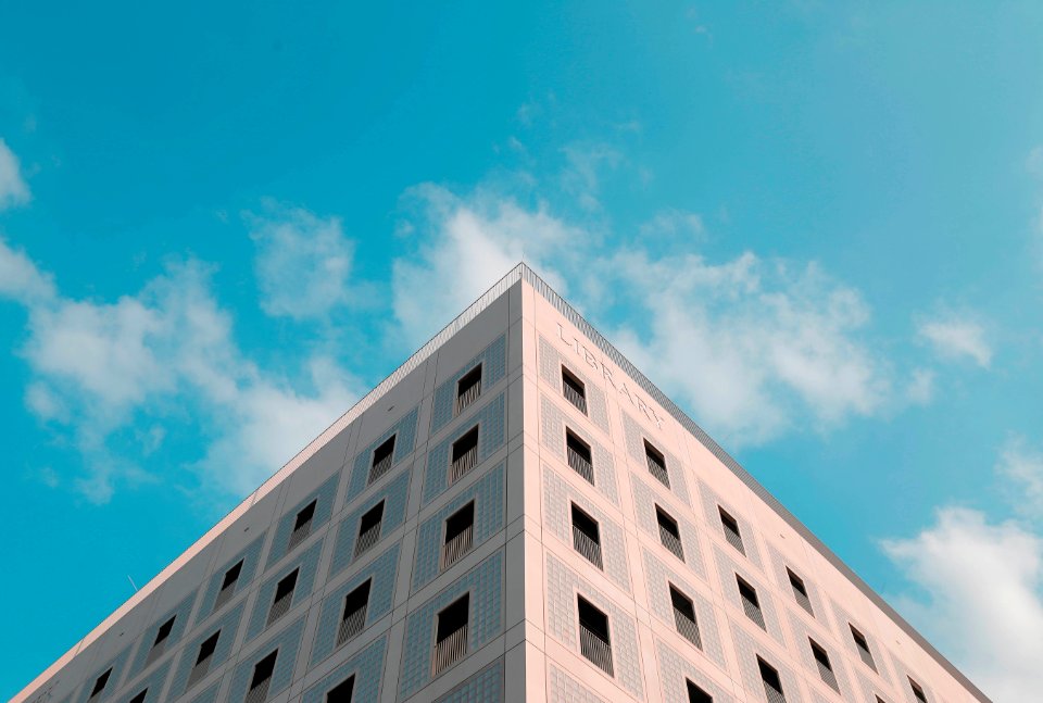 shallow focus photography of Library building under blue and white cloudy skies at daytime