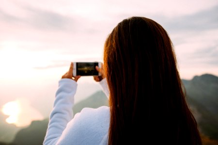 person holding smartphone taking photo photo