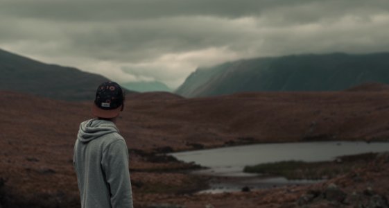 photo of man wearing gray hoodie and black cap photo