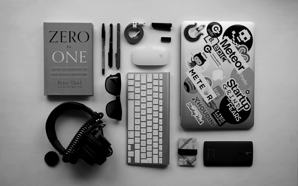 black corded headphones, silver MacBook, Apple wireless keyboard, and Apple Magic Mouse